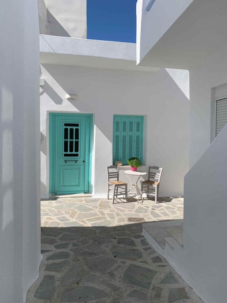 An enchanting street in Naxos' Old Town, with cobblestones, whitewashed buildings, and blooming bougainvillea.